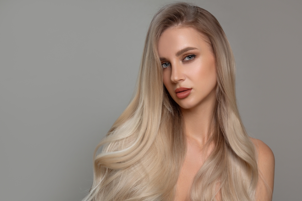 Keratine behandeling Almere: Deze vrouw laat zien hoe haar haar glad en pluisvrij is geworden na een keratine behandeling in een salon in Almere.