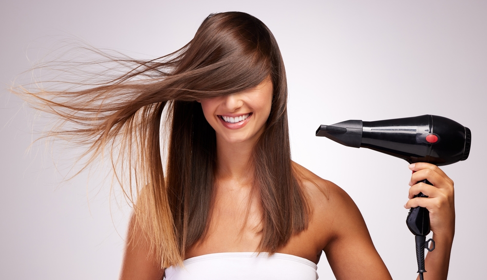 Deze vrouw gebruikt hittebeschermende producten tijdens de keratine behandeling om haar haar te beschermen tegen schade door hoge temperaturen bij het inwerken van de keratine.